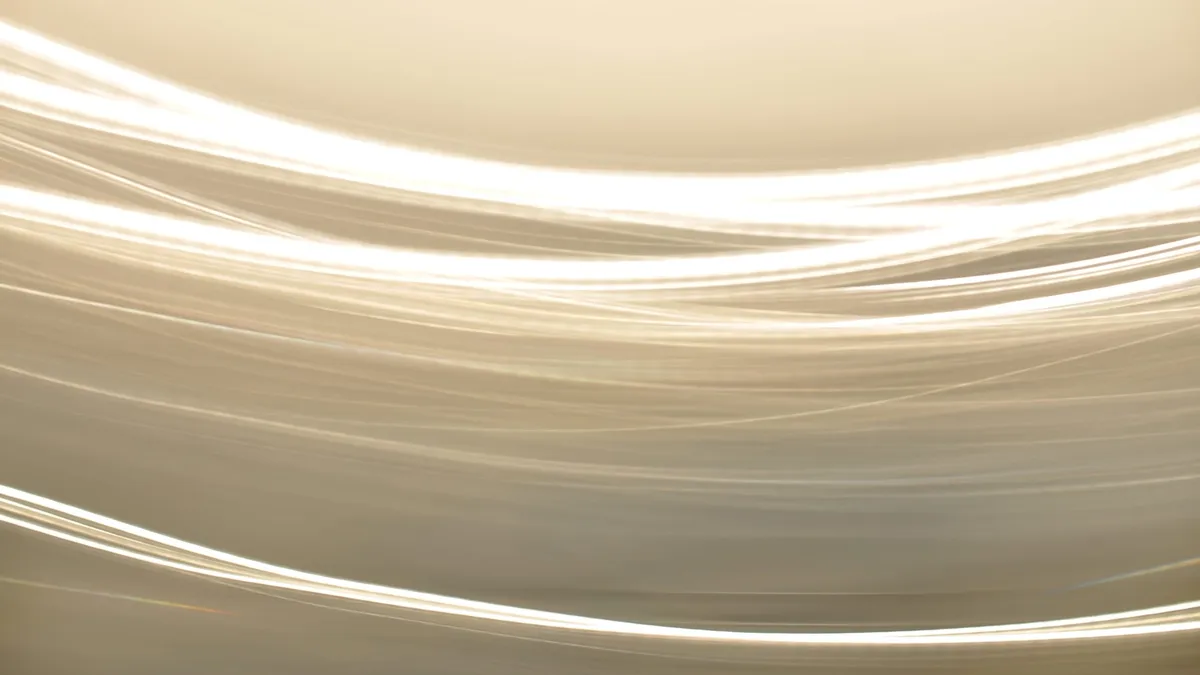 Abstract light stripes against a beige background.