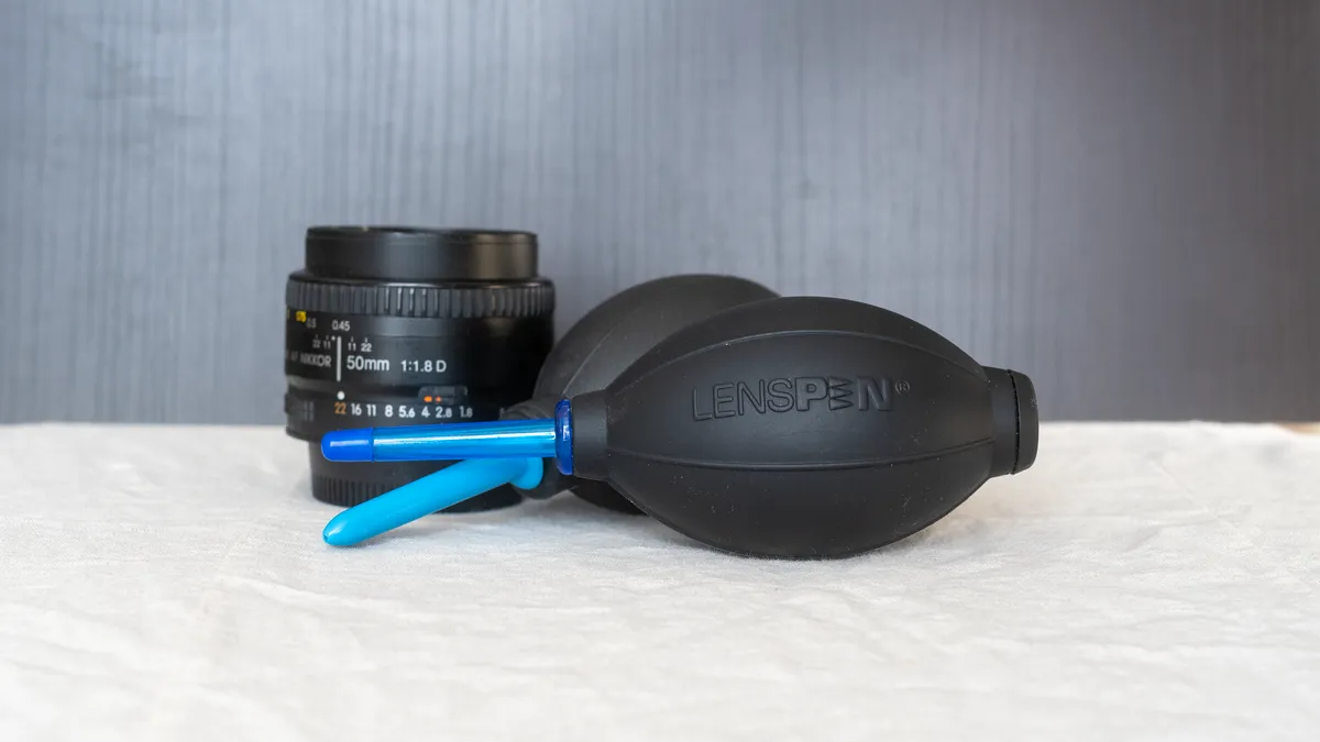Two air puffers laying next to a camera lens.
