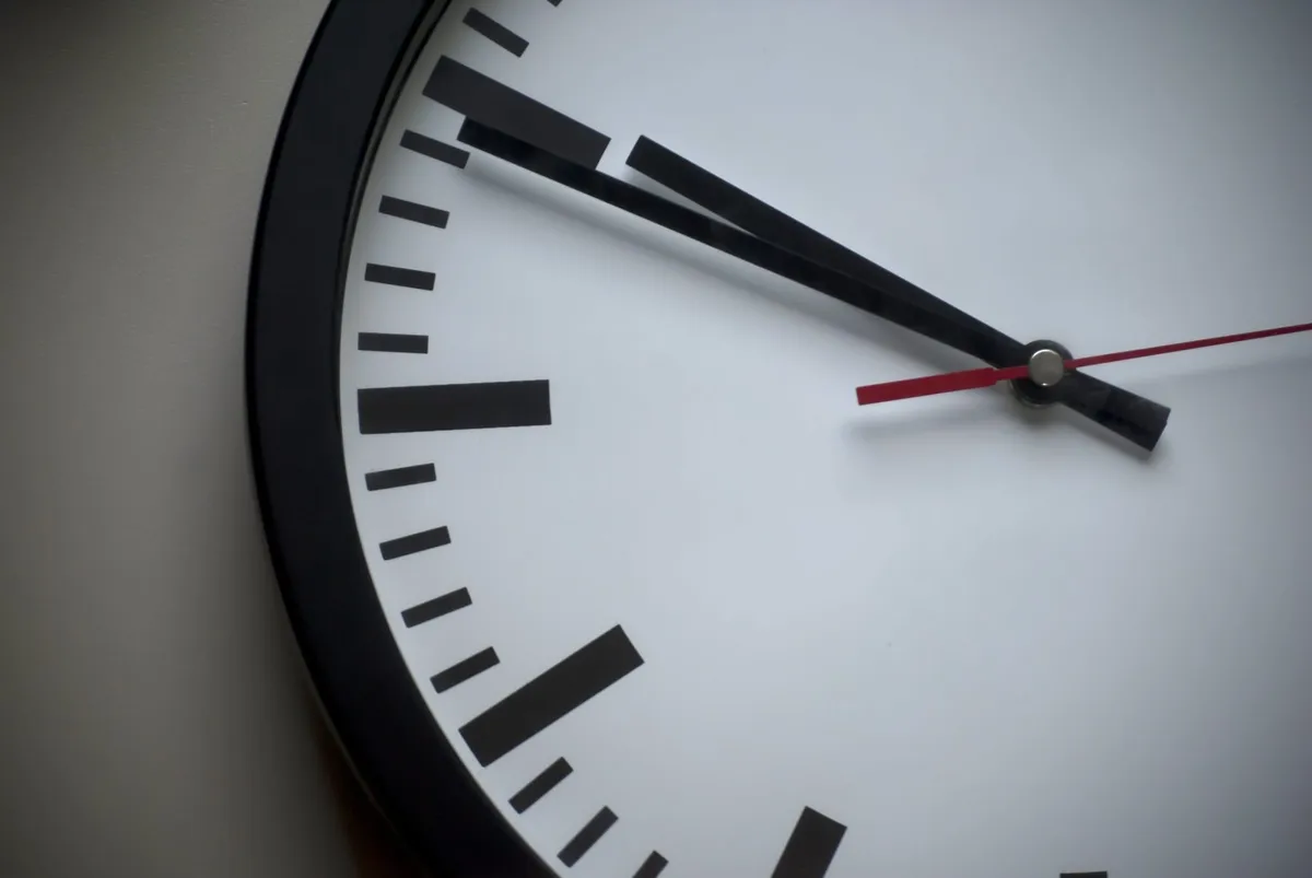 A close-up of the hands of a wall clock.