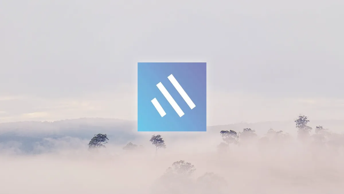 The Topical logo in front of a forest covered by fog.