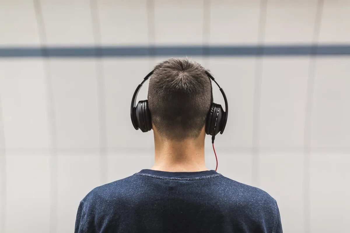 The back of the head of a man wearing headphones.