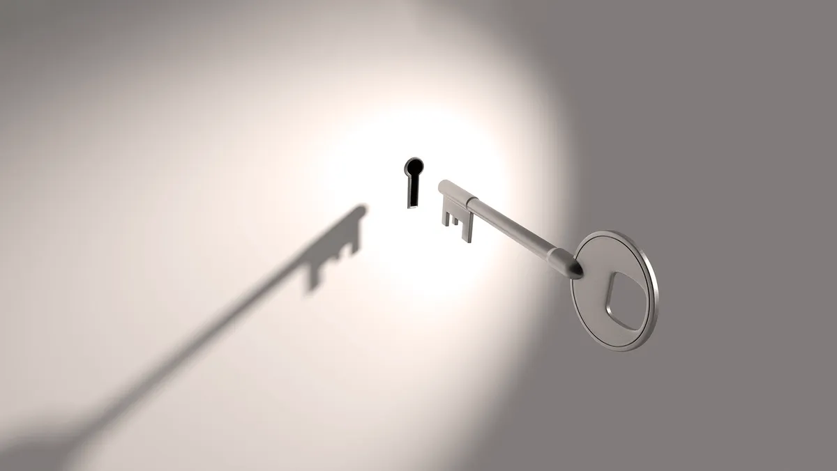 A key floating in thin air in front of a keyhole.