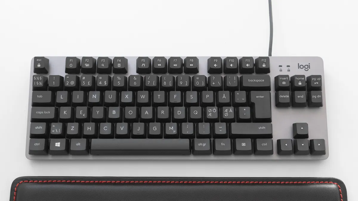A Logitech-brand mechanical tenkeyless (TKL) keyboard with the keycaps rearranged to spell out “Linux keyboard.”