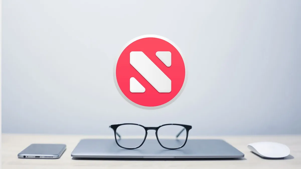 The Apple News logo hovering in mid-air above a MacBook with reading glasses on top of it. An iPhone and an Apple Mouse is next to the MacBook.