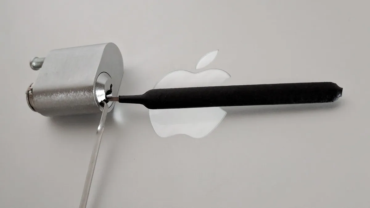 A lockpicking set opening a deadbolt lock in front of the Apple logo.