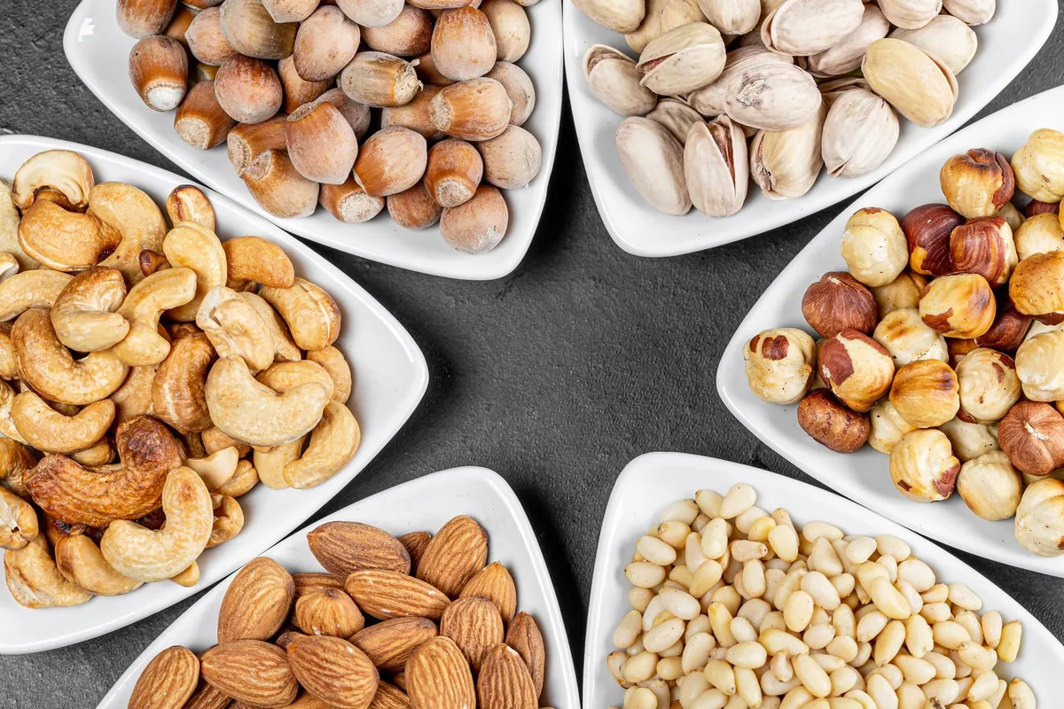 Triangular bowls filled with various nuts arranged in a star-shape.