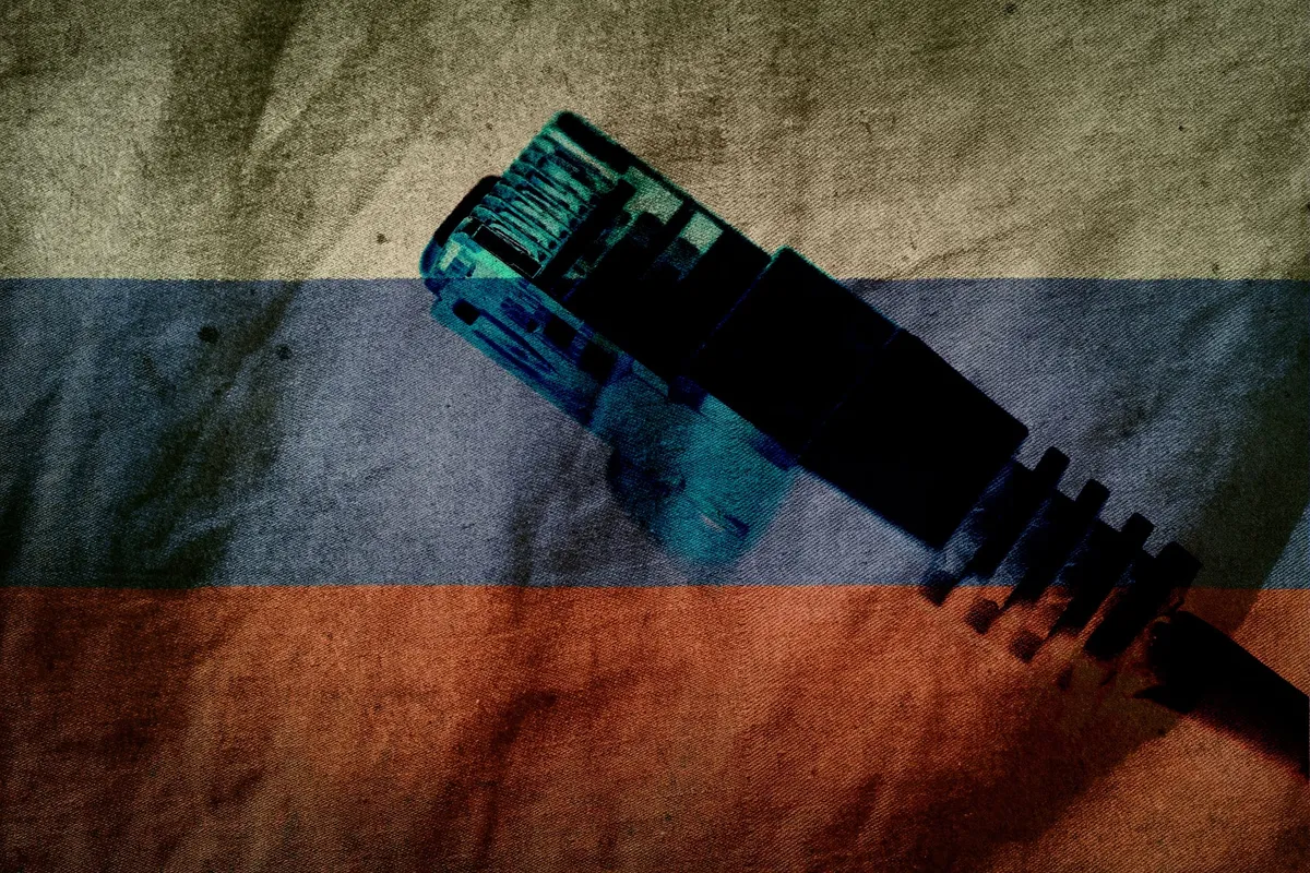 An RJ45 Ethernet connector in front of a worn-out Russian flag.
