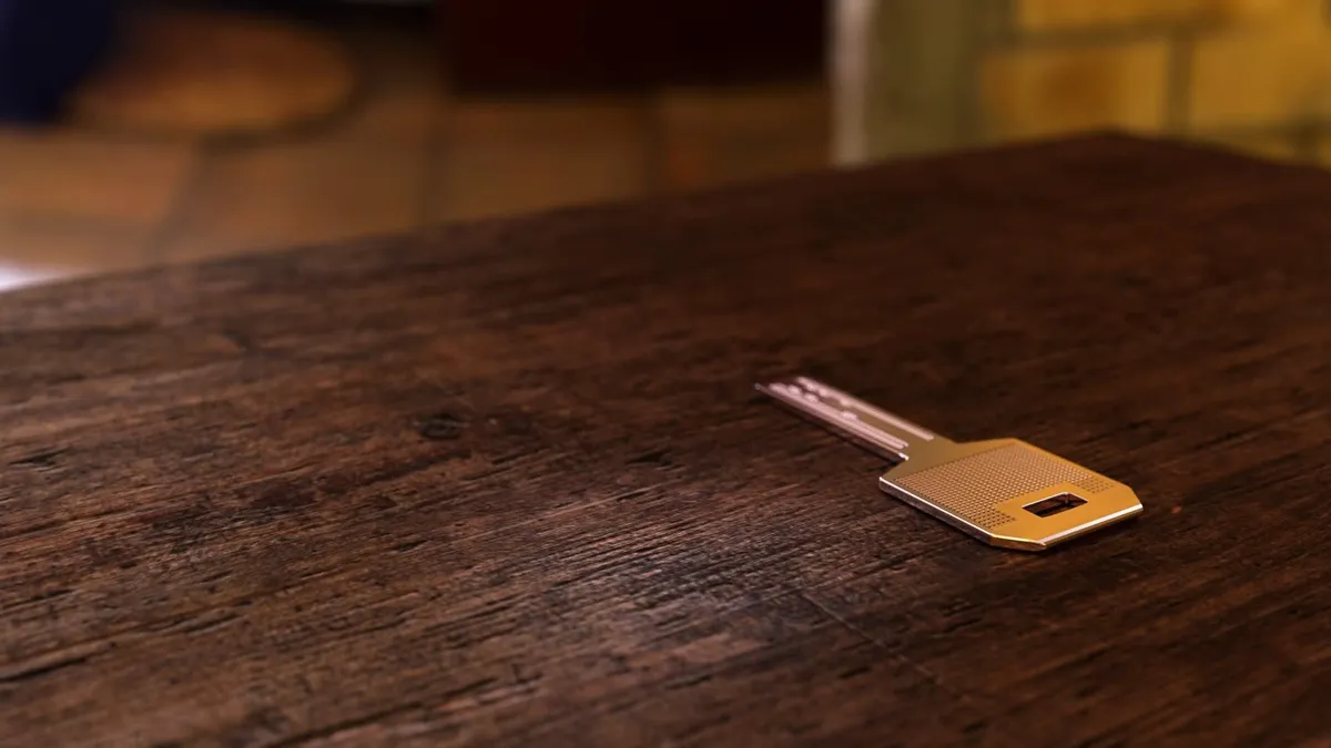 A golden key laying on a table.