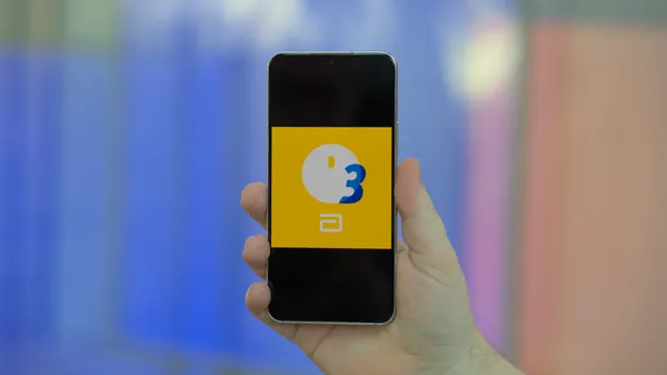 A Samsung Galaxy smartphone showing the Abbott FreeStyle Libre 3 app icon on screen.