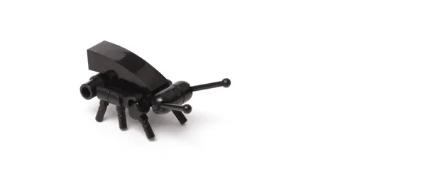 A small black bug made out of Lego bricks.