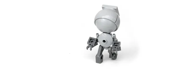 A small robot with a large head made out of Lego bricks.