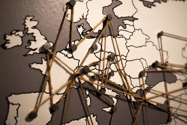 A map of Europe with pins placed in several countries. The pins are interconnected by pieces of string.
