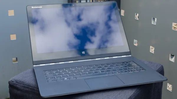 A Lenovo Yoga 3 Pro reflecting clouds from the sunset on the screen.