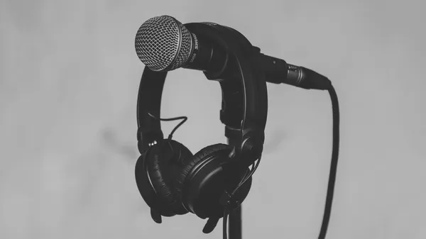 A pair of headphones resting on a microphone stand.