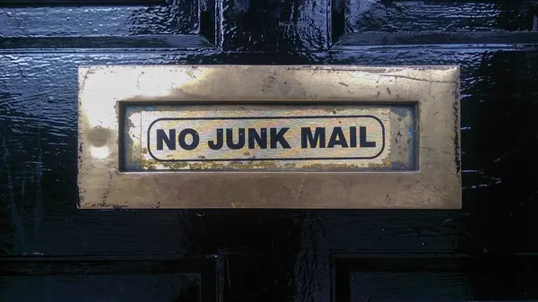 A door mail slot lableled “No Junk Mail”.