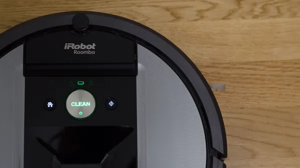Looking down on the top control panel of the Roomba 960 sitting on a wooden floor.