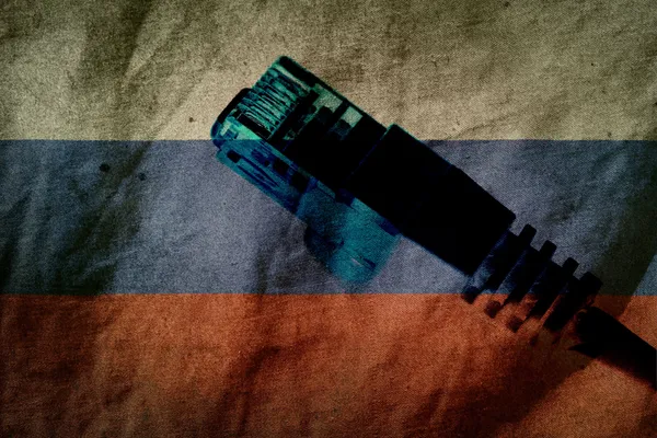 An RJ45 Ethernet connector in front of a worn-out Russian flag.