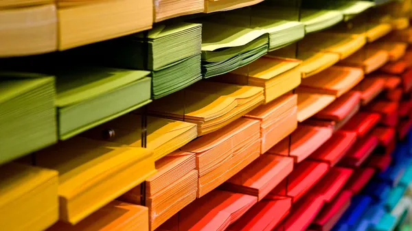 Trays with stacks of differently colored paper sheets.