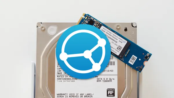 The Syncthing logo on top of an NVMe drive laying on top of a hard disk drive.