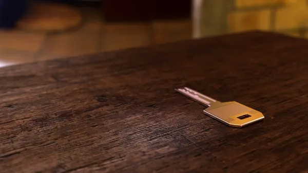 A golden key laying on a table.