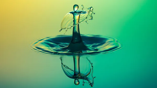 A drop of water in the shape of a man impacting a water surface.