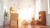 Chambre ensoleillée avec des cartons de déménagement empilés et des coches et flèches flottantes