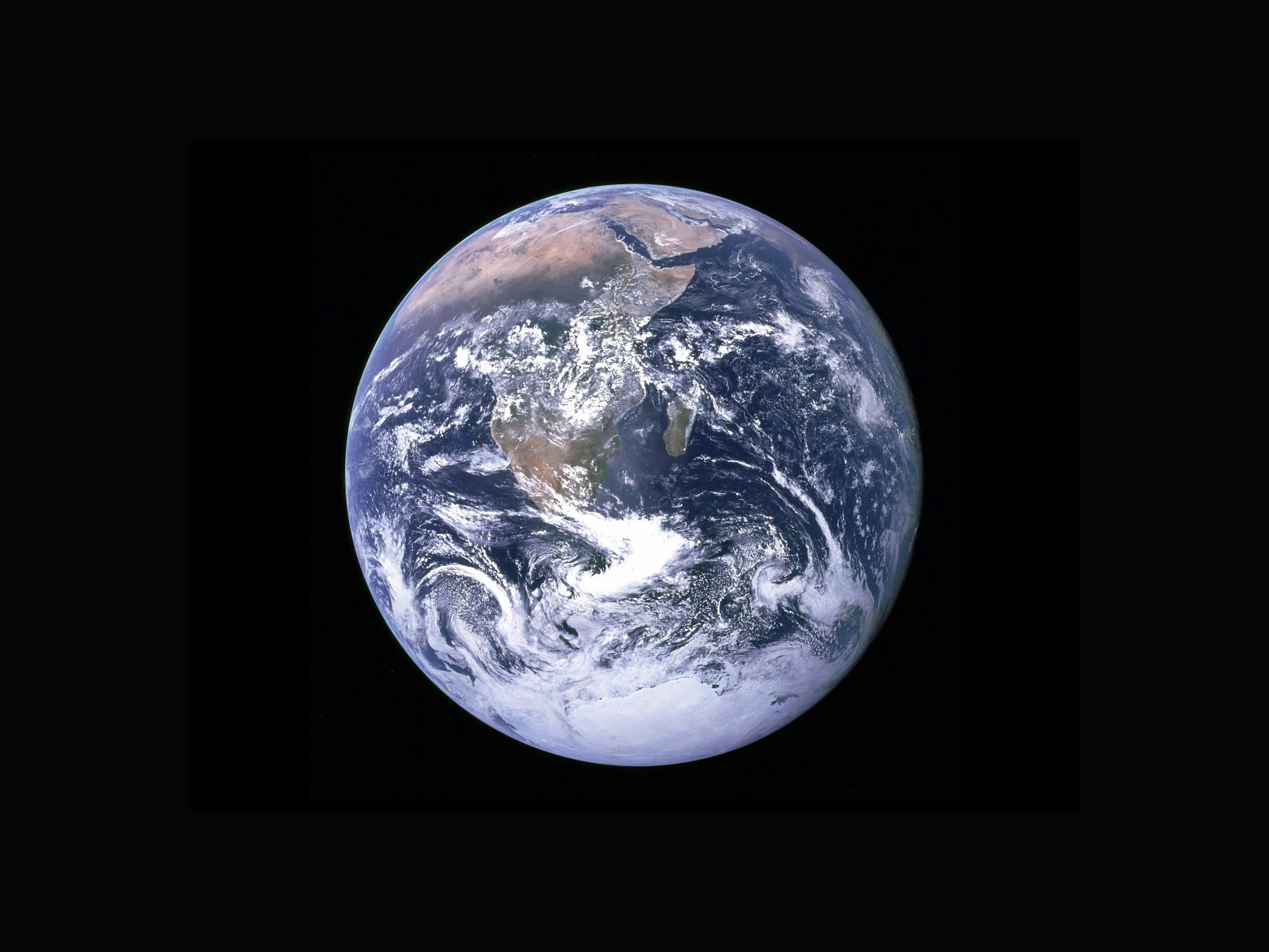 Earth viewed from space with the African continent and cloud formations visible.