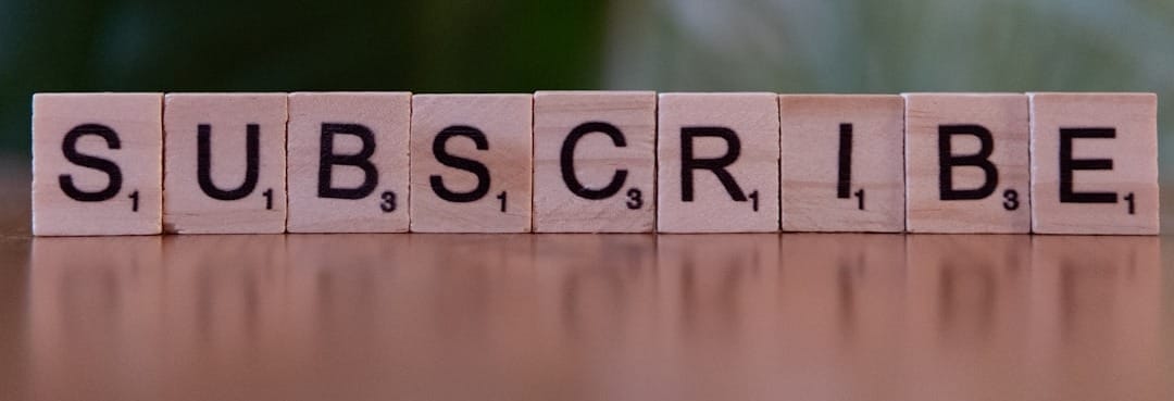 A wooden block spelling subscribe on a table