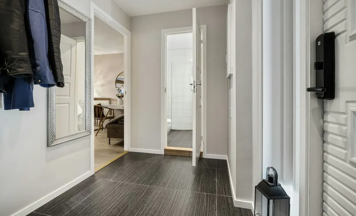 A hallway with a black and white floor and white walls