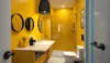 Salle de bain petite et cosy avec des accents audacieux en jaune et noir, éclairage élégant ...