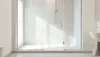 Douche à l'italienne minimaliste avec panneaux en verre transparent, bac de douche en pierre