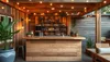 Bar confortable en bois de palettes recyclées avec un éclairage chaleureux et des plantes