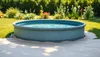 Un jardin serein avec une piscine ronde hors sol sur un terrain nivelé 