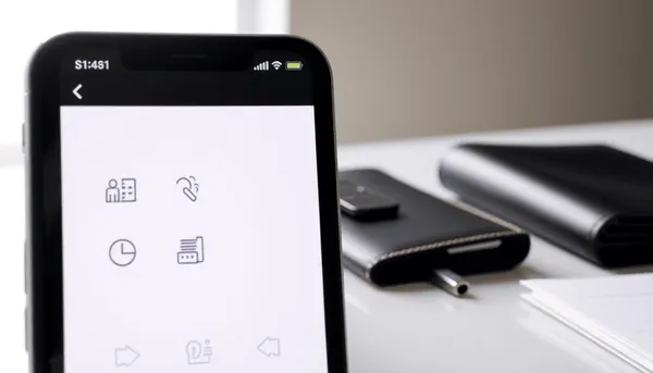 Smartphone moderne affichant une application bancaire sur un bureau propre à côté d'un portefeuille