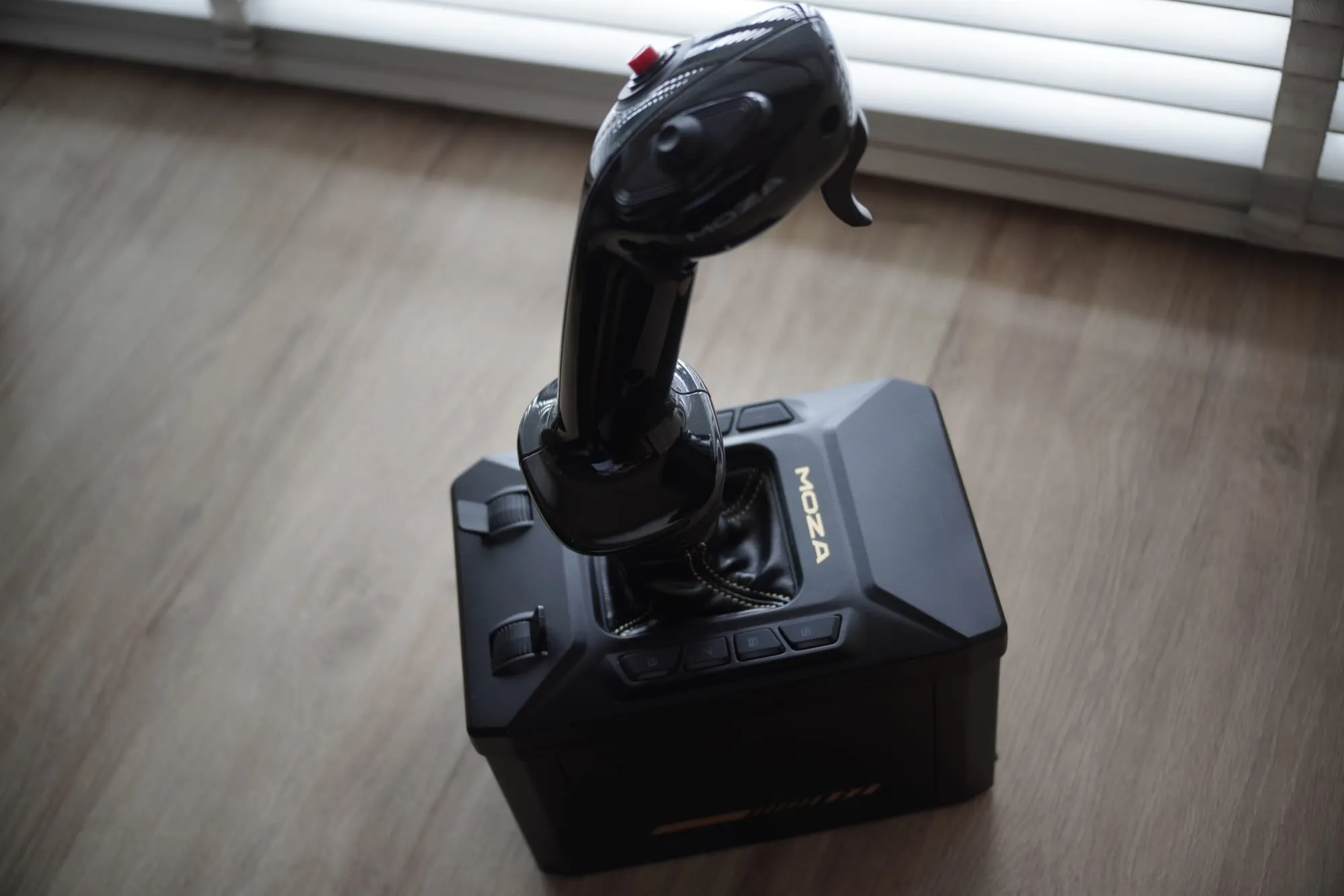 The AB6 base and fitted grip seen from a high angle, showing the MOZA logo and the base's own button panel
