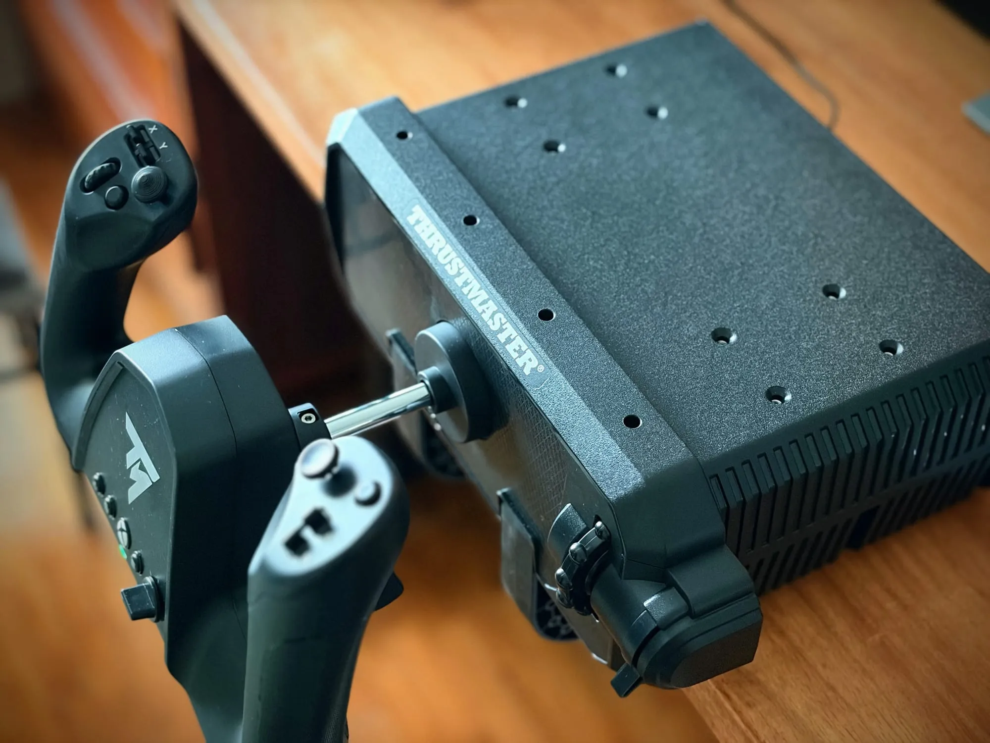 Rear three-quarter view: the steel pitch shaft entering the back of the case, the flat top face drilled with a grid of threaded mounting holes, and vent slots along the side.