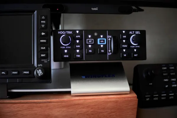 WingFlex DAP 500 autopilot panel with GFC 500-style controls on a home flight sim desk, navigation tablet beside it, MSFS on the background monitor