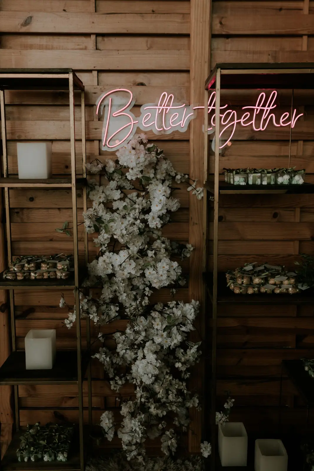 Elegant rustic decor featuring a 'Better Together' neon sign, with shelves and floral arrangements.