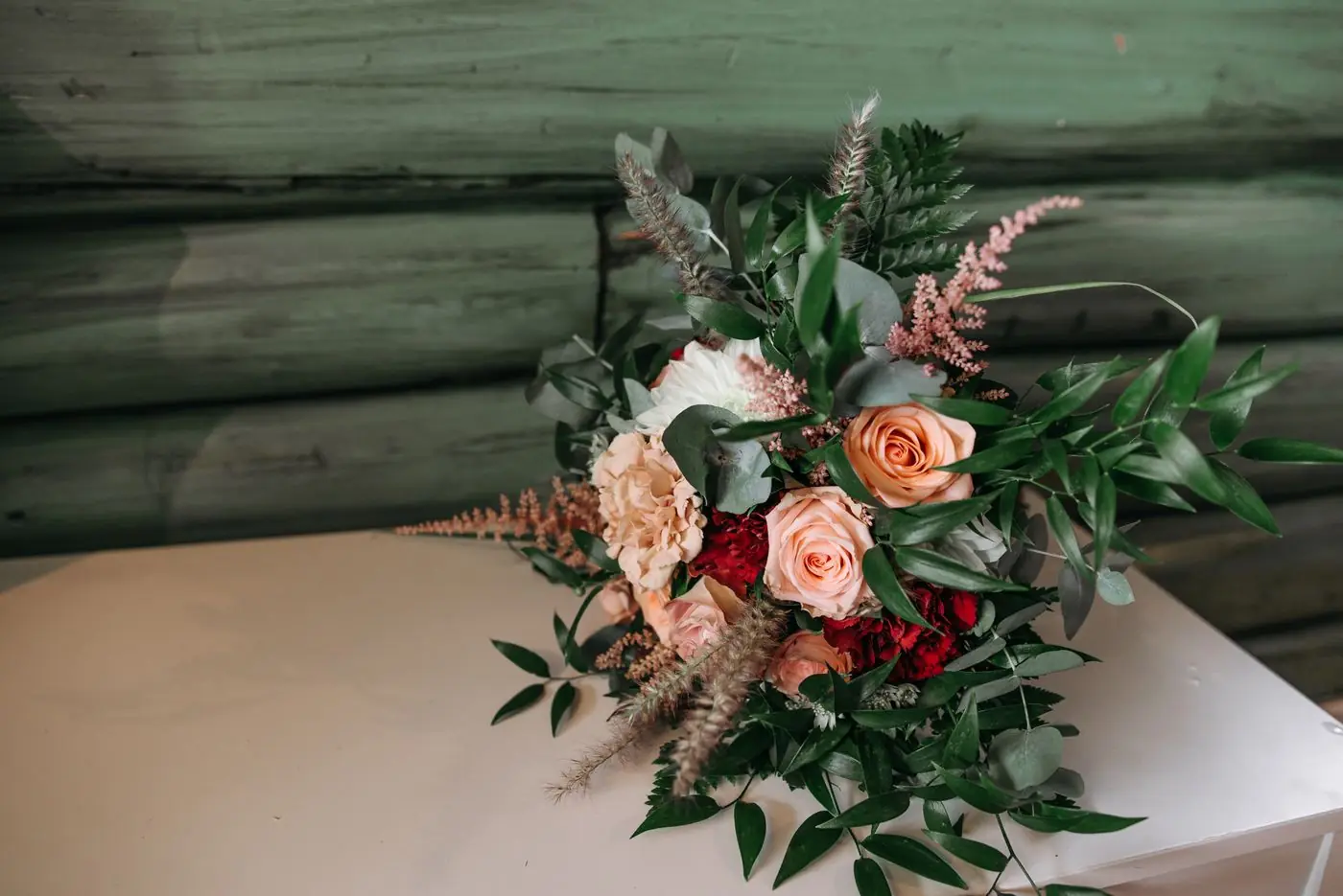 A stylish bouquet featuring roses and greenery on a rustic background. Perfect for weddings or celebrations.