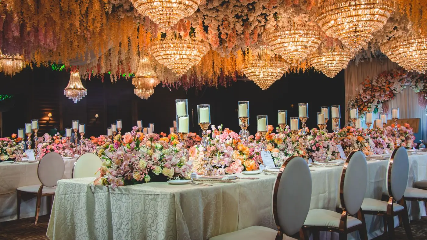Elegant banquet hall decorated with chandeliers and flowers, perfect for weddings and receptions.