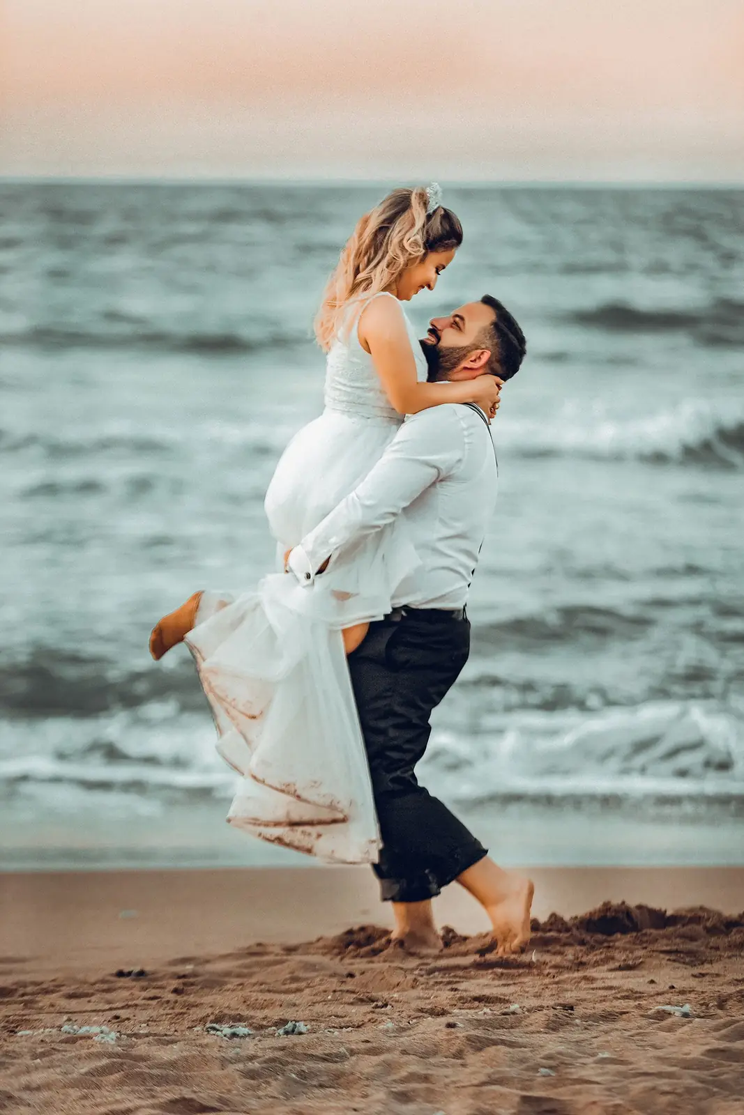 A joyful couple embraces on a Şile beach, capturing the essence of a romantic seaside wedding.