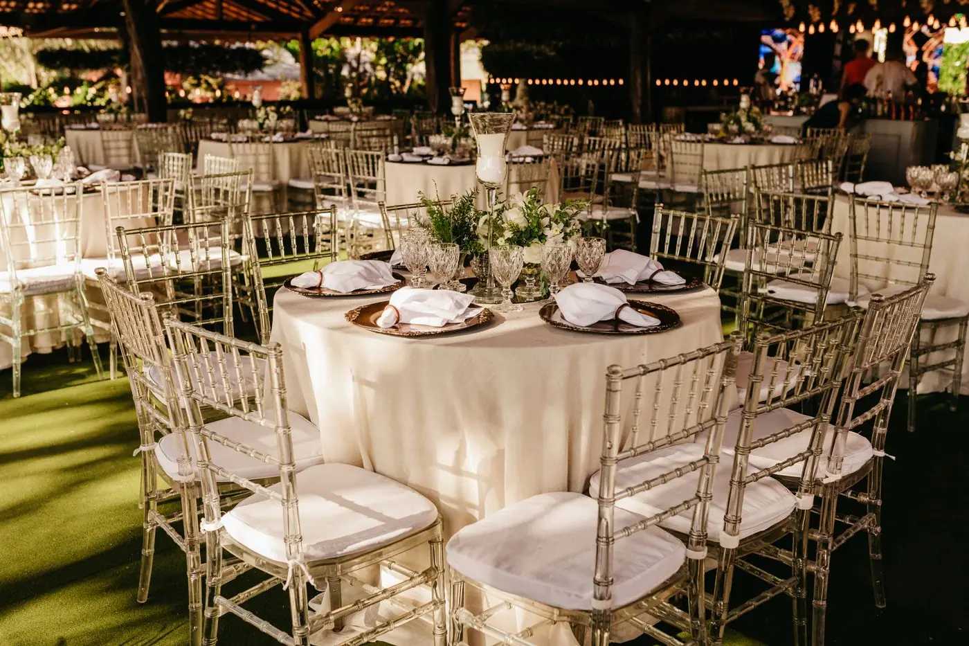 Chic outdoor wedding reception with elegant table setup and floral arrangements.