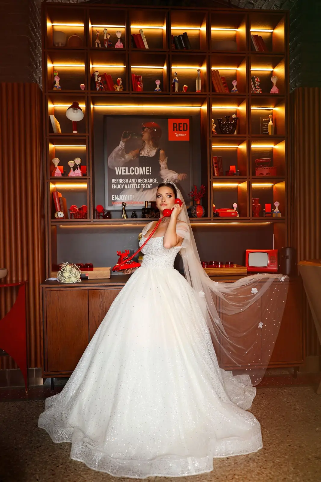Bride in elegant gown poses indoors with an accent on luxury and style.