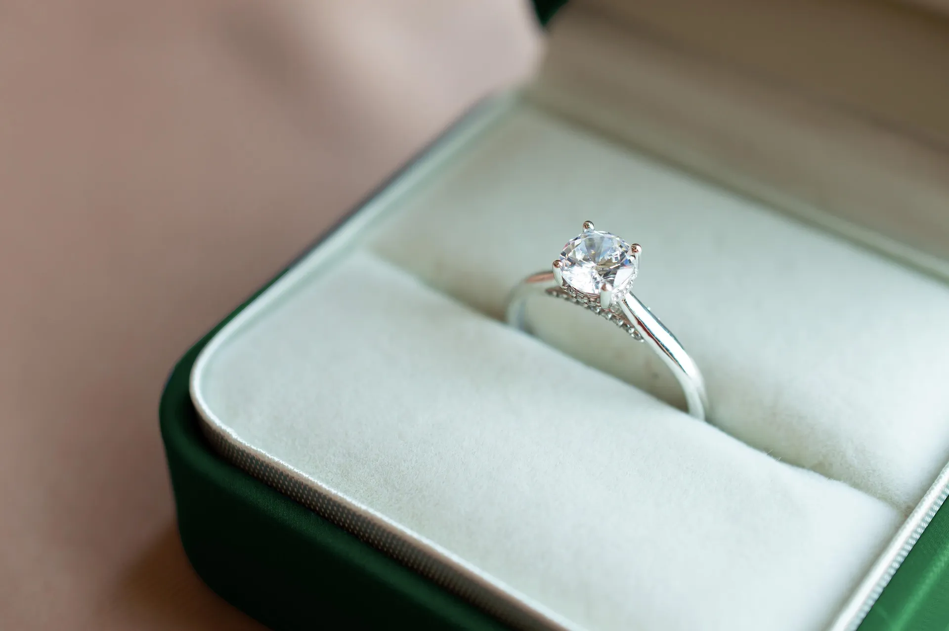 Diamond engagement ring resting in an open velvet ring box.