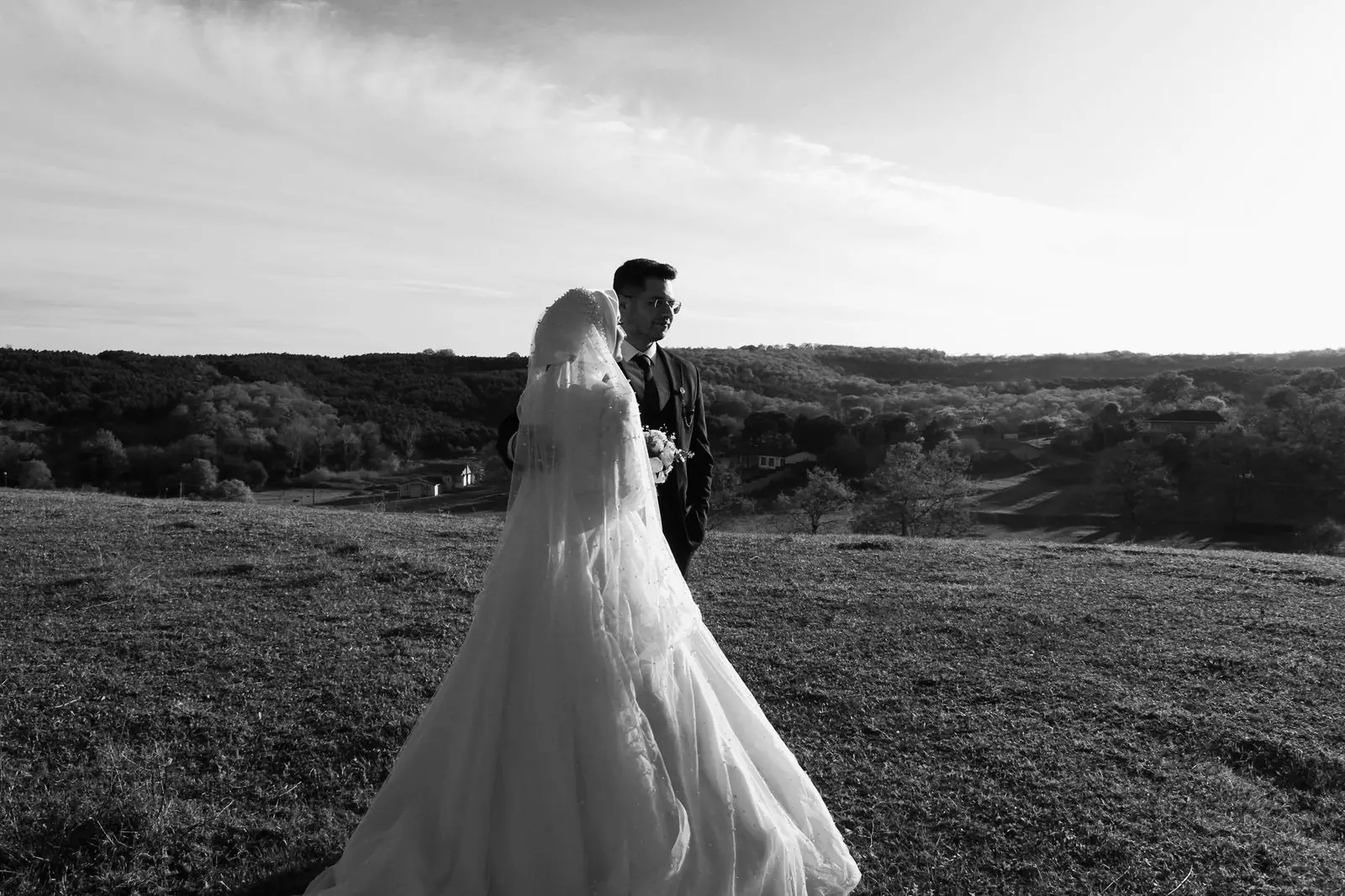 Elegant outdoor wedding with bride and groom in scenic rolling hills. Black and white photography captures timeless romance.