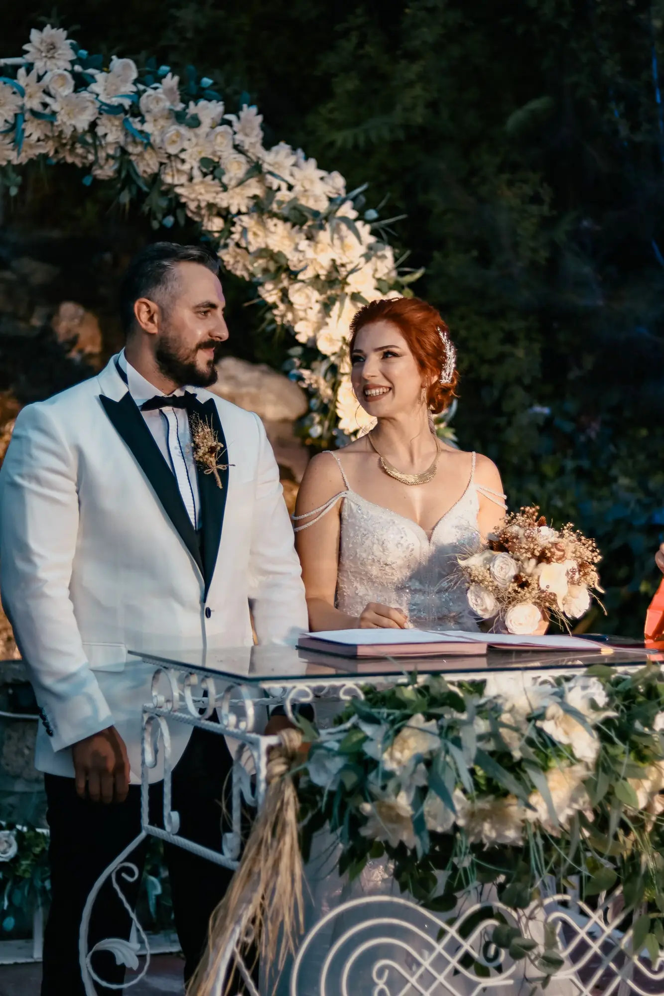 Charming outdoor wedding ceremony featuring a joyful bride and groom amidst beautiful floral decor.