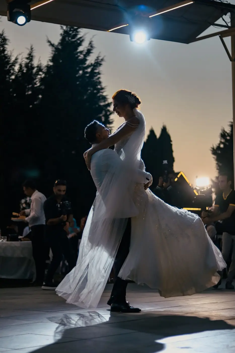 A romantic sunset dance of a newlywed couple in wedding attire, creating a picturesque moment.