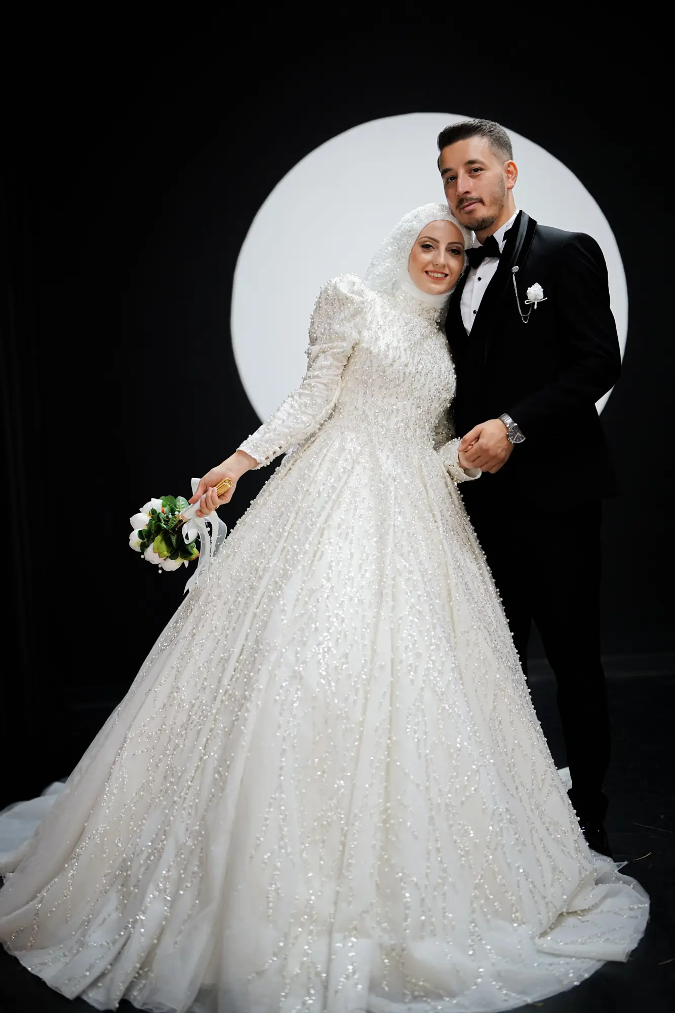A couple shares a passionate kiss in front of a mirror, wearing wedding attire indoors.