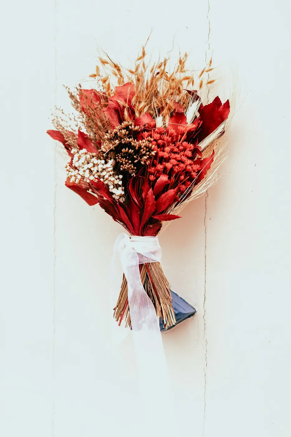 A vibrant dried flower bouquet featuring red blooms, perfect for rustic decor.