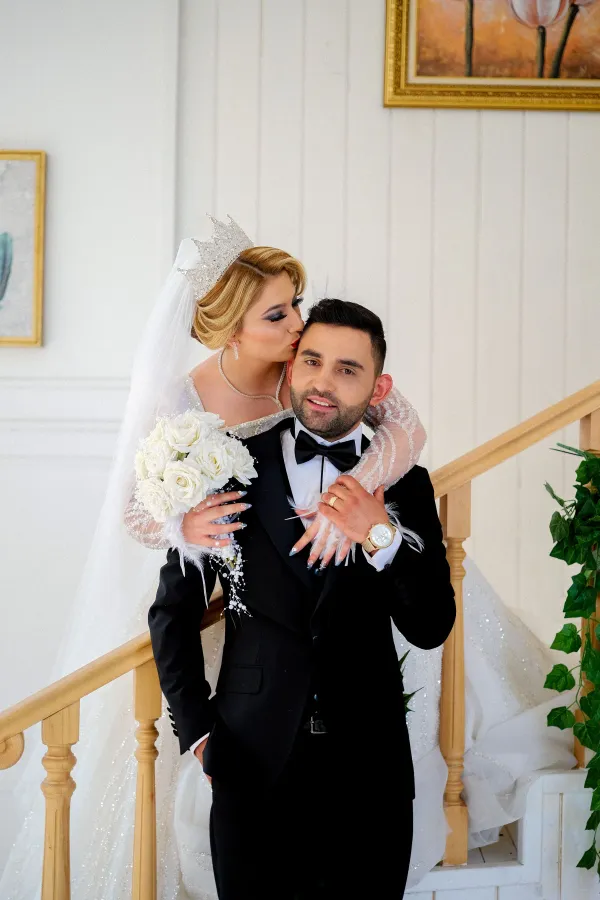 Intimate close-up of a newlywed couple in elegant wedding attire, showcasing jewelry and details.
